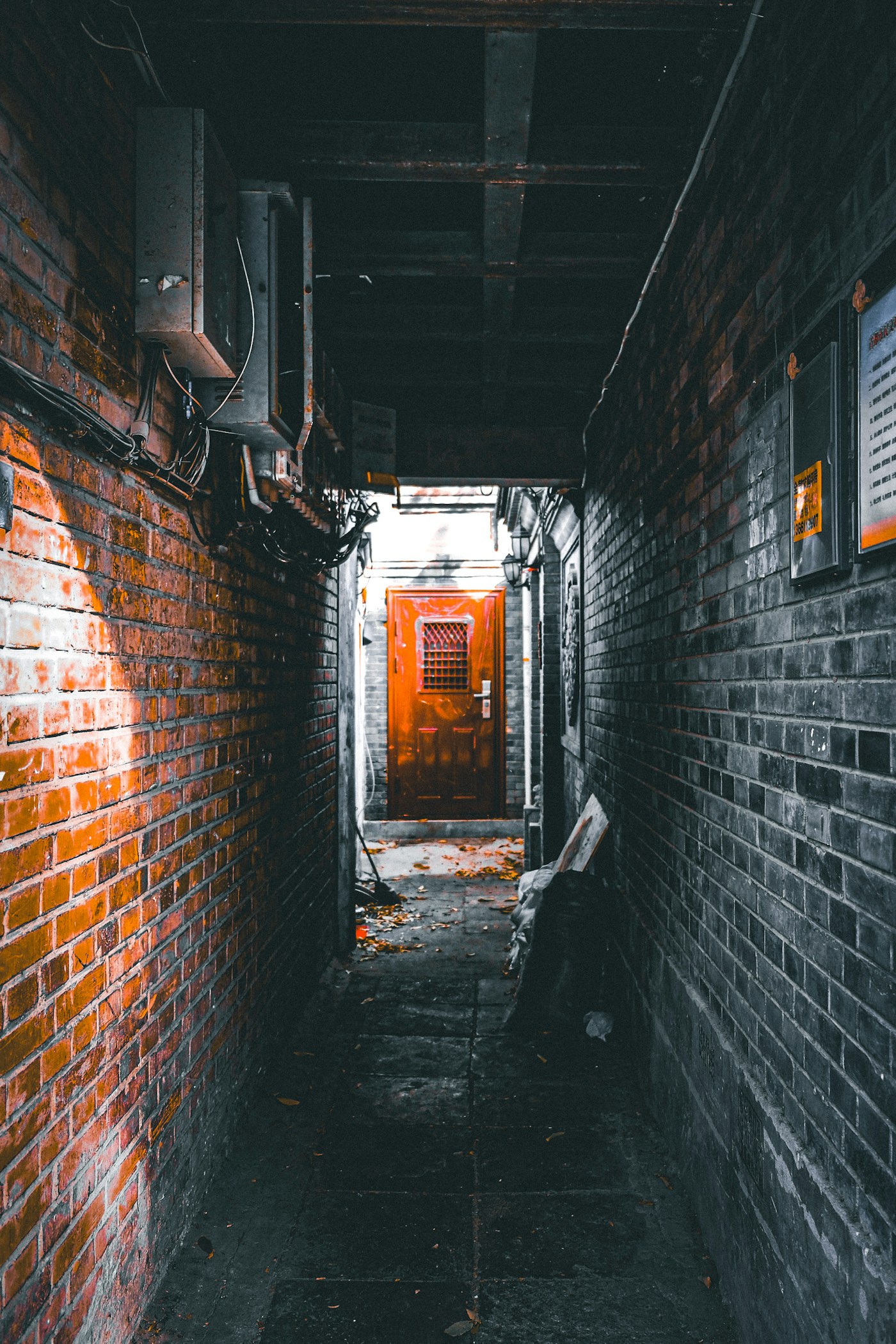 A narrow Beijing hutong lane ending at a red door