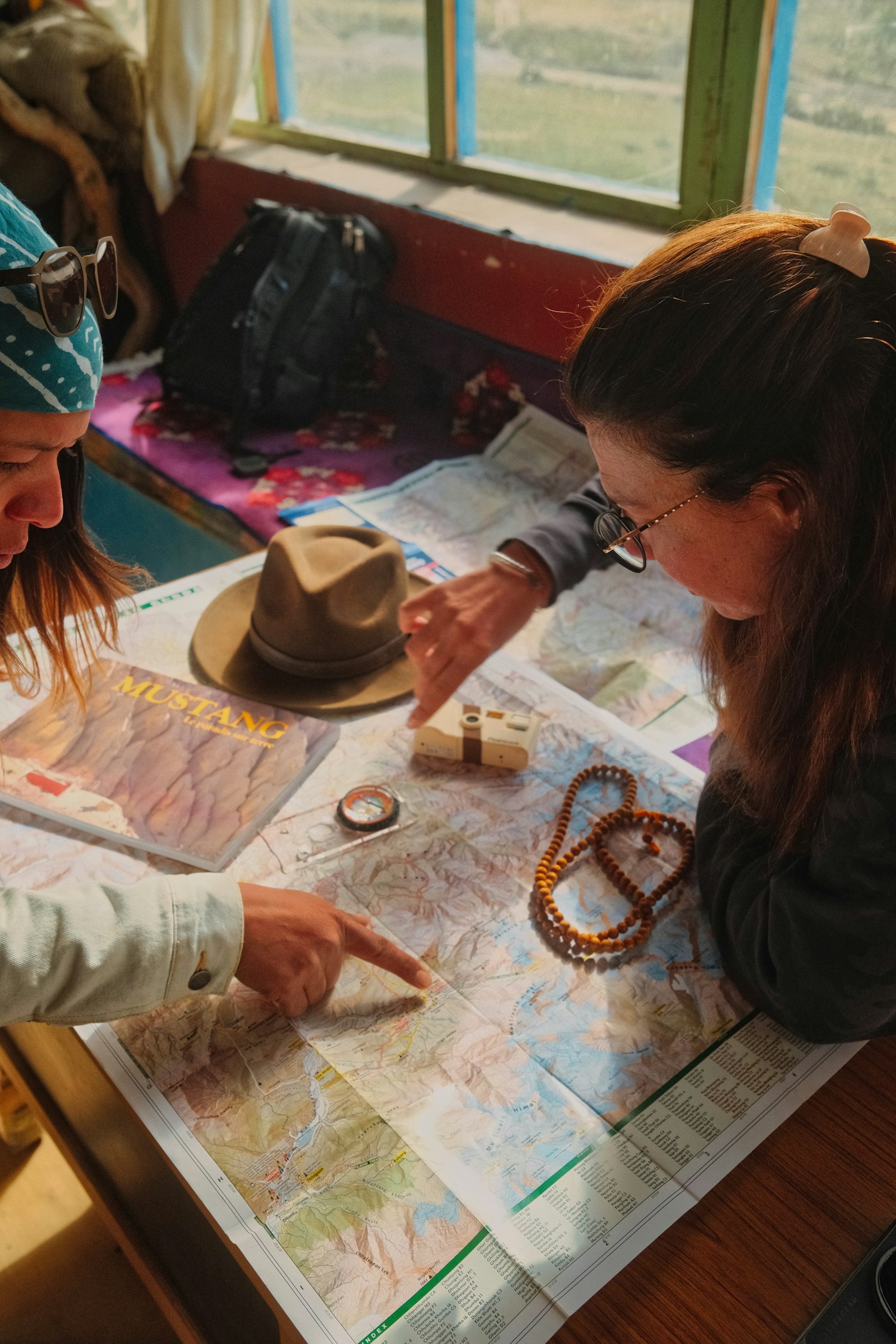 Two travellers pointing across a map while planning a journey